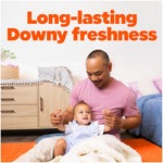 Lifestyle image of parent and baby on a rug under headline 'Long-lasting Downy freshness' promoting the fragrance