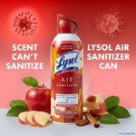 Lysol Air Sanitizer can surrounded by whole and sliced apples and cinnamon sticks on red background