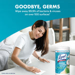Person using a Lysol wipe on a table with a Lysol canister nearby and 'Goodbye, Germs' header