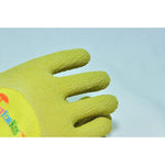 Macro close-up of textured glove fingertips in yellow-green foam coating against a neutral background