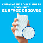 Hand holding a textured Magic Eraser pad against a blue background with text about micro-scrubbers reaching surface grooves