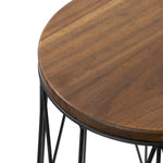 Tight crop of the acacia wood tabletop edge and black metal frame, highlighting wood grain and finished rim