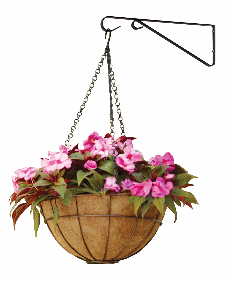 Black iron wall-mounted plant hanger bracket holding a chained coconut-fiber hanging basket with pink flowers