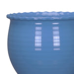Close-up of the scalloped rim and glossy surface of a blue rounded planter