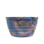 Blue and copper marbled round bowl with ridged sides, isolated on white background.