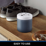 Lifestyle image of the Mainstays charcoal odor eliminator jar with white perforated lid placed on a wooden shelf near shoes.