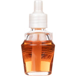 Close-up of a clear refill bottle filled with amber fragrance oil and a white ribbed cap