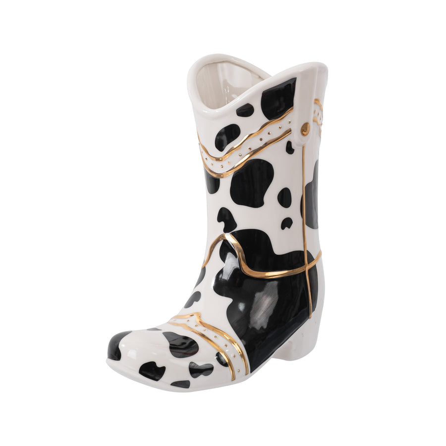Glossy ceramic cowboy boot planter with black cowhide spots and gold trim, angled view