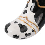 Close-up of the boot cuff showing black spot pattern and gold decorative trim on ceramic