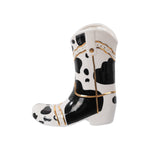 Side view of glossy white ceramic cowboy boot planter with black spot pattern and gold accents
