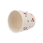 Top-down angled view of an empty cream ceramic planter featuring red cherry decorations