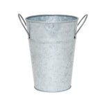 Single galvanized metal bucket planter with tapered body and two looped side handles on white background