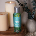 Mainstays Garden Rain room spray can styled on a wooden surface beside lit candles and decorative vases
