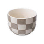 Straight-on view of a round ceramic planter with birch gray and cream checkered exterior and visible interior
