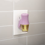 Lilac Mainstays fragrance plug inserted into a wall outlet with a visible scent vial attached
