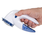 Hand holding a compact white and blue Mainstays lint remover showing ergonomic handle and button