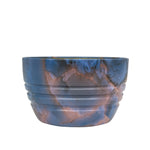Front view of a blue and copper marbled round bowl with subtle ridges, on white background.