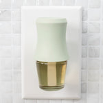 Mainstays soft sea glass fragrance plug inserted in a white wall outlet with tile background
