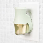 Soft sea glass Mainstays fragrance plug mounted in an electrical outlet with clear oil bottle