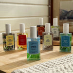 Group of Mainstays room spray bottles in various scents arranged on a wooden surface, including Cranberry Mandarin
