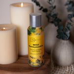 Styled scene with Mainstays Wild Honeysuckle room spray placed near lit candles and decor