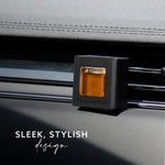 Black Maison & Muse square vent clip with amber fragrance insert clipped to a car air vent