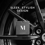Black Maison & Muse square air freshener suspended against a car wheel background with ‘sleek, stylish design’ text