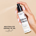 Hand holding and spraying Maison & Muse Marilyn air mist bottle with beige background and text graphic