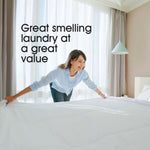 Person making a bed in a bright room with overlaid text 'Great smelling laundry at a great value'
