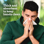 Man blowing his nose into a tissue with overlay text 'Thick and absorbent to keep hands clean'