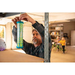 Man installing a RESCUE! TrapStik by hanging it from a shelf in a garage or storage area, family blurred in background