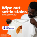 Man inspecting a white t-shirt with a visible stain and text claiming to wipe out set-in stains