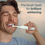 Smiling man brushing teeth with a white Philips Sonicare handle and a DiamondClean brush head, text promoting brilliant whitening.