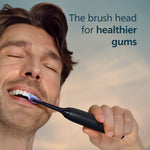 Close-up of a man brushing with a black Philips Sonicare handle and a G3 brush head, with slogan