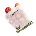 Semi-transparent Matter compostable bag filled with apples, showing printed brand name and leaf graphics.