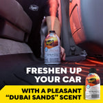Meguiar's Dubai Sands can sprayed on a vehicle floor with pink mist, hand and car interior visible