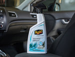 Meguiar's Re-Fresher spray bottle placed on a car seat with interior dashboard visible in background