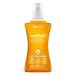 Front-facing Method ginger mango laundry detergent bottle with orange liquid and pump cap on white background.