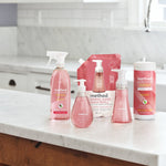 Assorted Method pink grapefruit products arranged on a kitchen counter including spray bottle and wipes