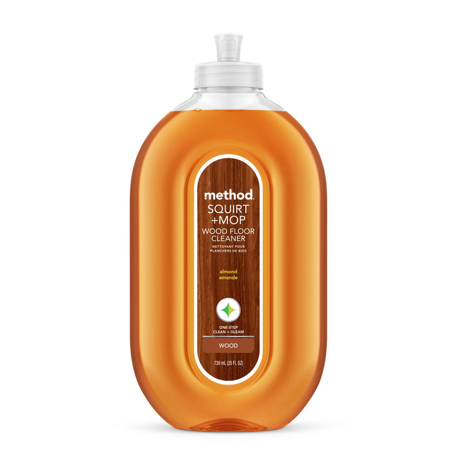 Clear oval bottle of Method Squirt + Mop wood floor cleaner with almond-scent label and amber liquid
