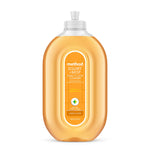 Clear amber-orange Method Squirt + Mop hard floor cleaner bottle with front label and flip-top cap on white background