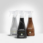 Three Method spray bottles staged together with Granite Polish in the center, flanked by stainless steel and wood polish bottles.
