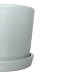 Close-up crop of a semi-matte mint ceramic planter and saucer showing rim and texture on white
