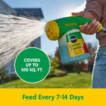 Hand holding Miracle-Gro Garden Feeder spraying water with text bubble 'Covers up to 500 sq. ft.' visible.