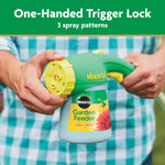Close-up of two hands holding Miracle-Gro Garden Feeder showing one-handed trigger lock and nozzle adjustment.