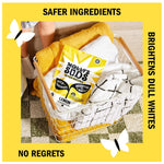 Lifestyle image of Molly's Suds lemon pouch placed inside a laundry basket with towels on a rug, framed by yellow border