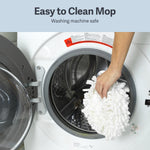 Hand placing a white microfiber mop head into the drum of a front-loading washing machine