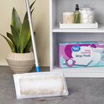 mop with a dirty pad on a gray floor next to a shelf holding a box of great value deep cleaning mop pads