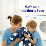Mother and child smelling a star-patterned blue blanket in a laundry room with the phrase ‘Soft as a mother’s love’