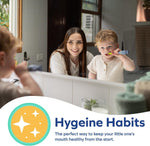 Mother smiling in mirror while toddler brushes teeth with a small toothbrush in a bathroom setting
